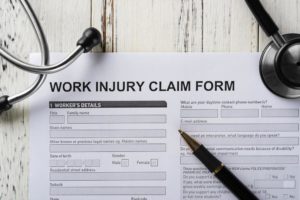top view work injury claim form with stethoscope