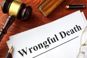 Wrongful death papers on desk with gavel. pen, and glasses